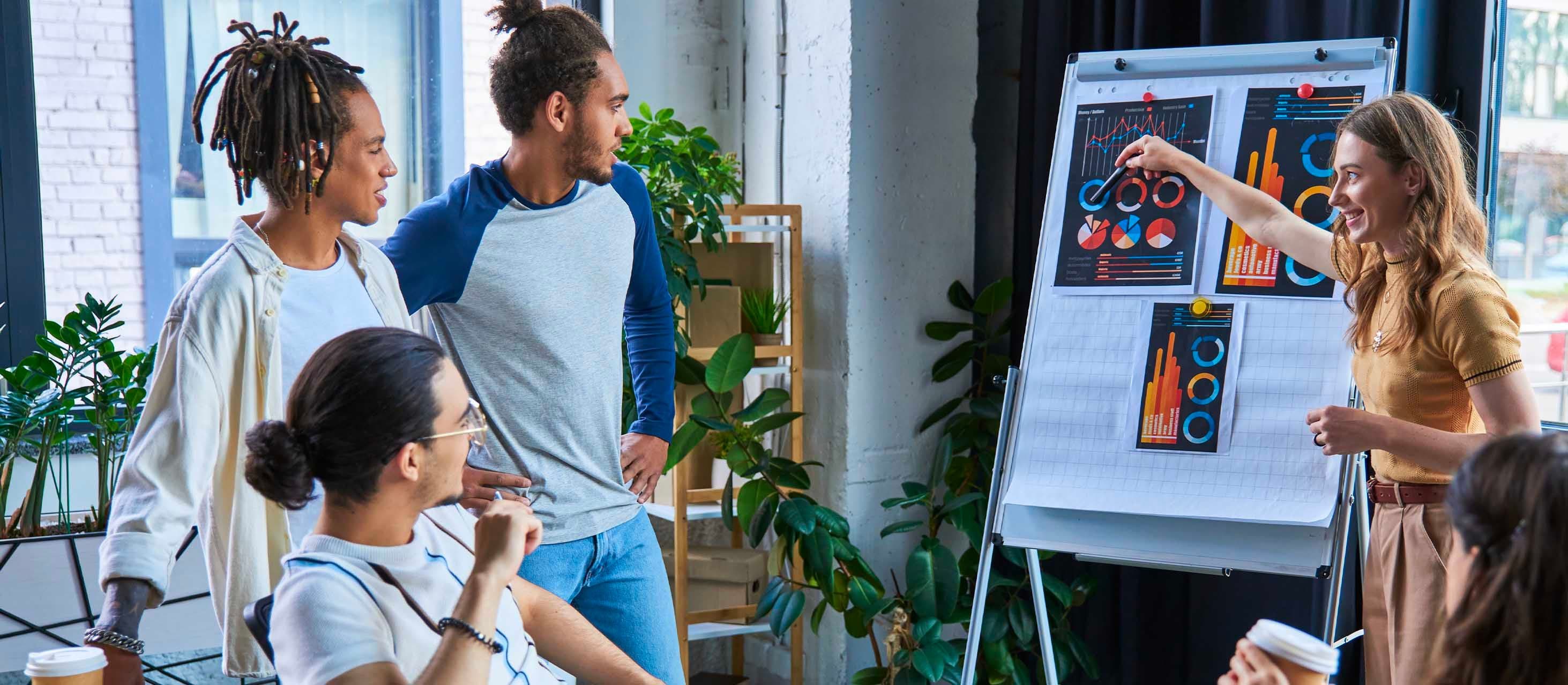 Studenti del Corso ITS Digital Marketing che analizzano contenuti visivi su una fotocamera in un ambiente collaborativo di lavoro